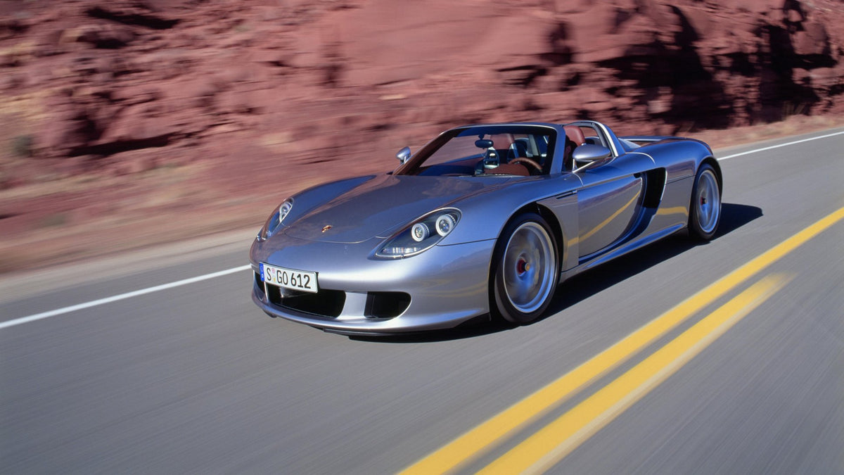 Silver Porsche Carrera GT driving on the road, official Porsche newsroom image